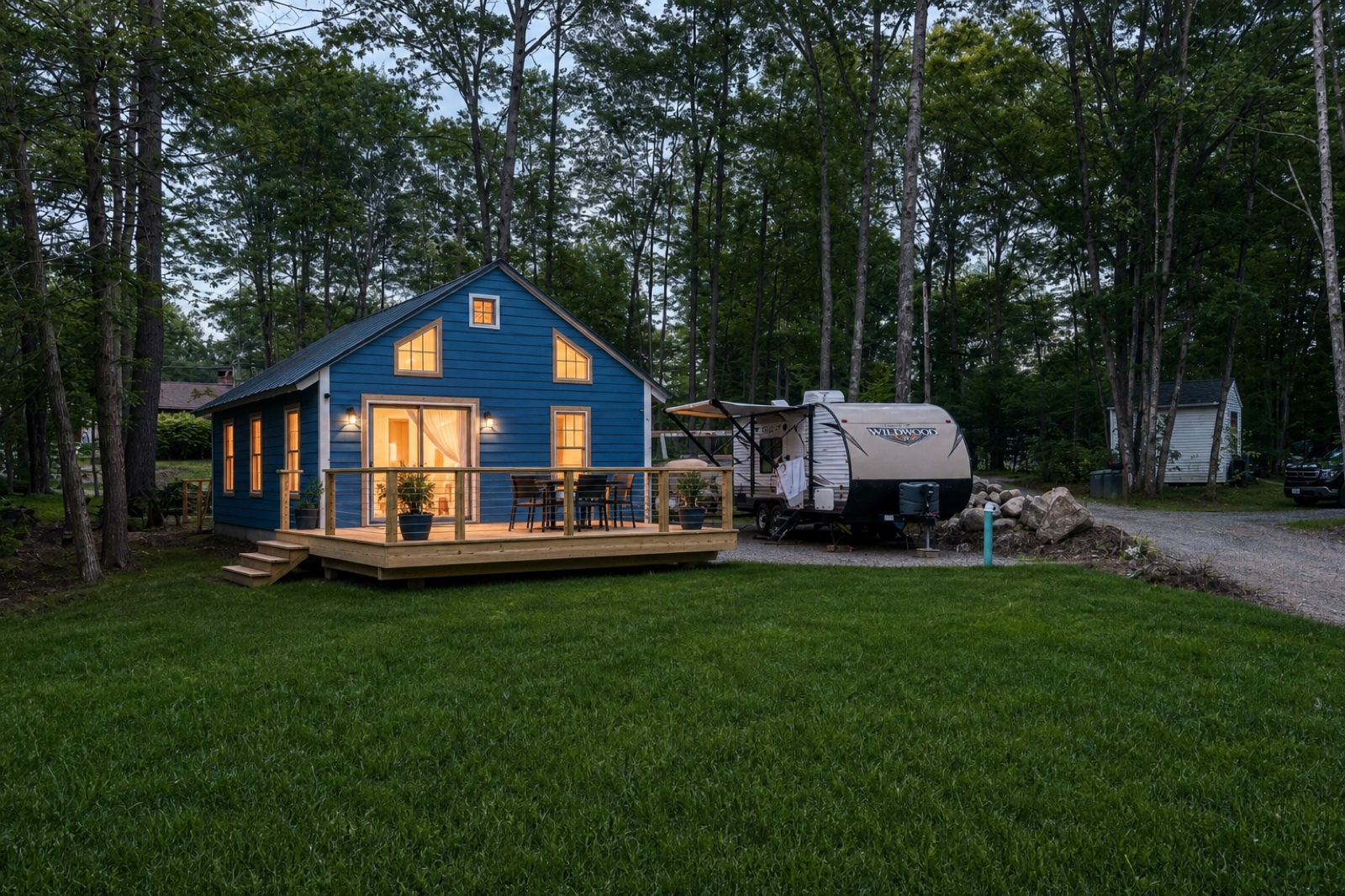 Canterbury cabin — finished exterior direction with sky-blue siding, wood deck, and wooded lot